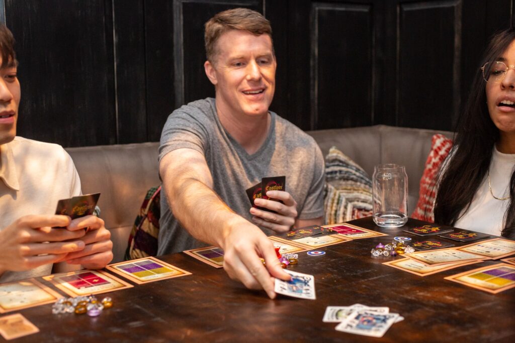 Candid photo of group of friends playing card game at table