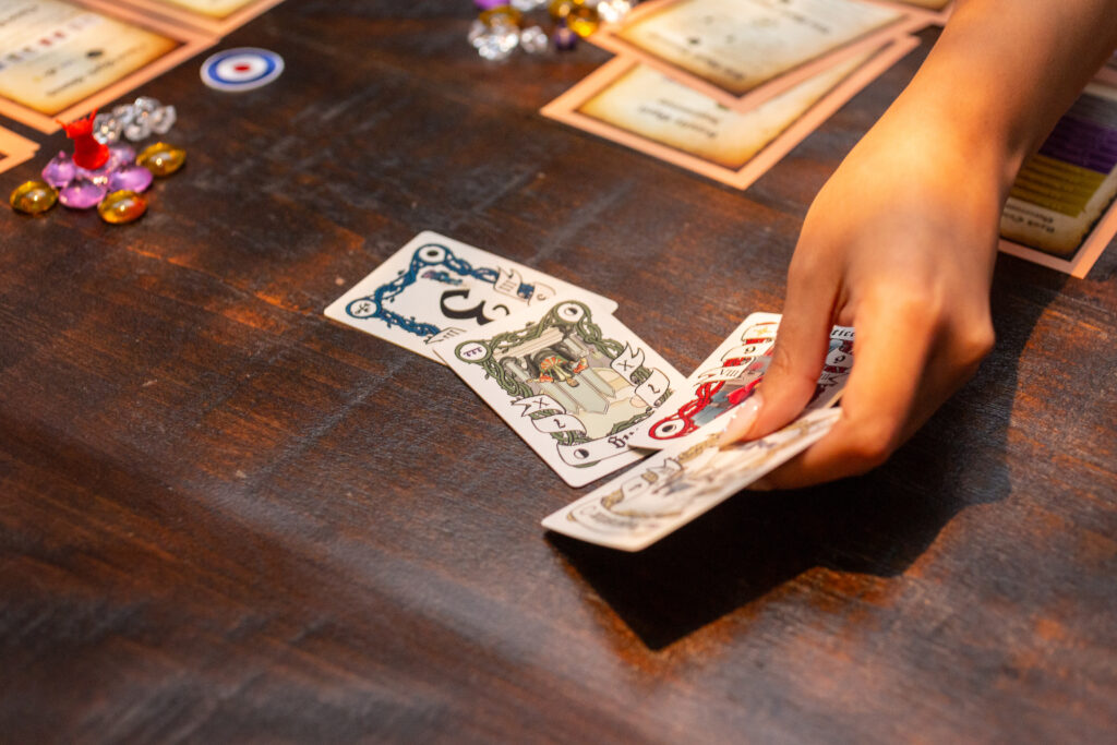 Close up photo of woman setting four fantasy playing cards on table