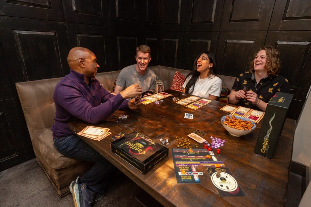 Candid photo of group of friends playing card game at table
