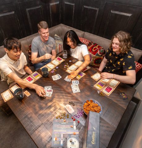 Overhead candid shot of group of friends playing card game at table