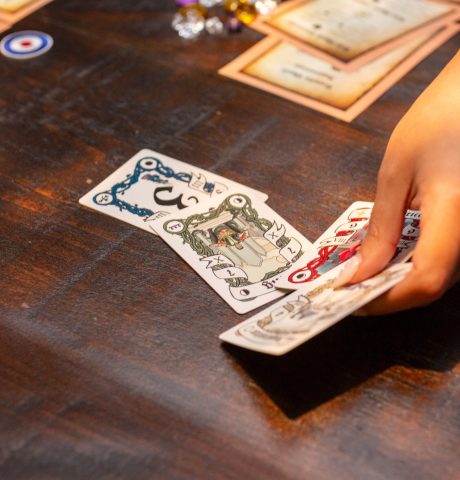 Close up photo of woman setting four fantasy playing cards on table